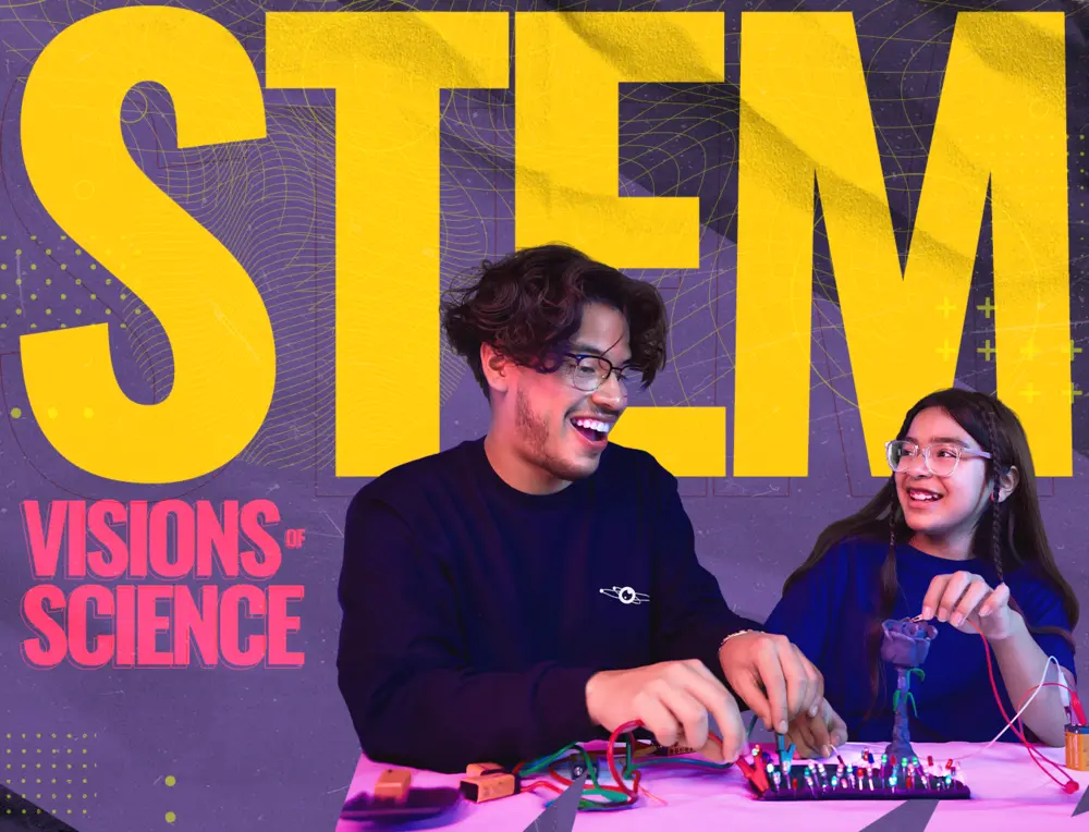 Two smiling students work on a STEM project with circuits, large yellow STEM text in the background.