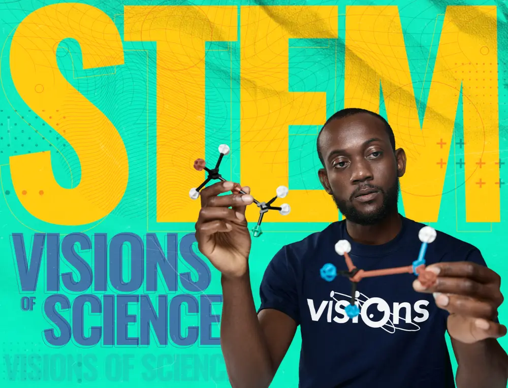 A man holds molecular models in front of a large STEM sign and Visions of Science text on a blue background.