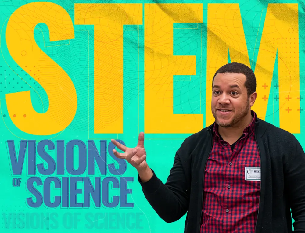 A man gestures and smiles in front of a colorful STEM Visions of Science background.
