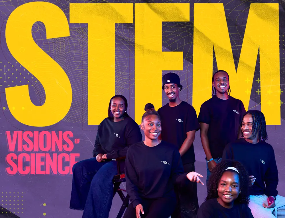 Six smiling Black youth in black shirts pose in front of large yellow STEM and Visions of Science text.