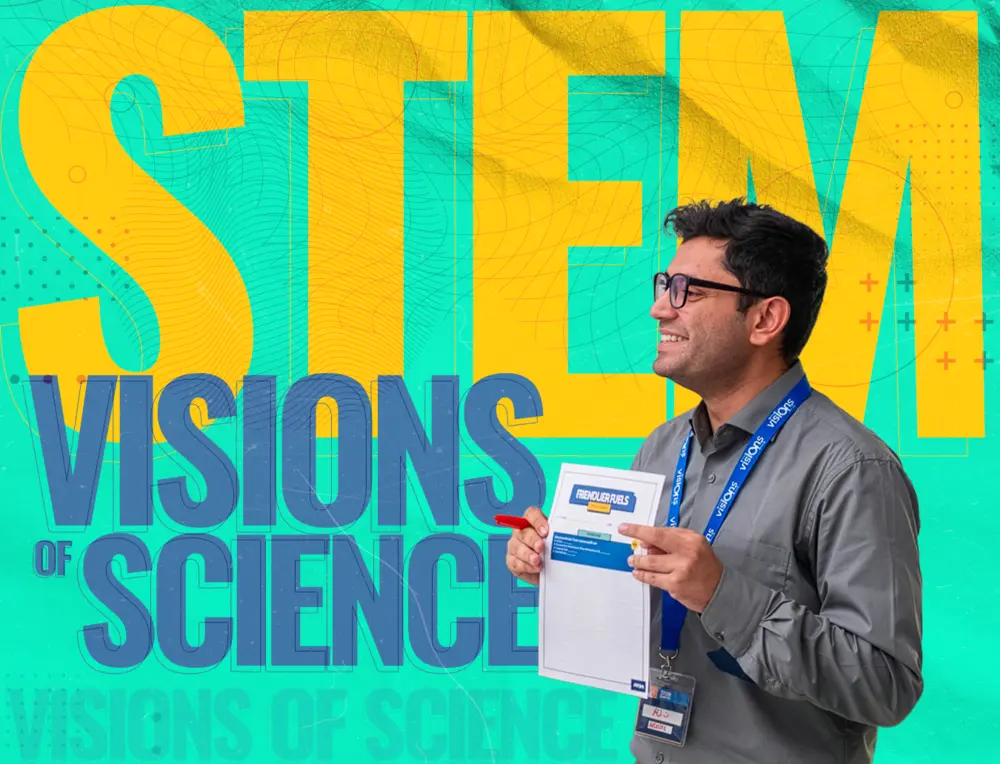Man smiling and holding a folder in front of a colorful STEM Visions of Science background.